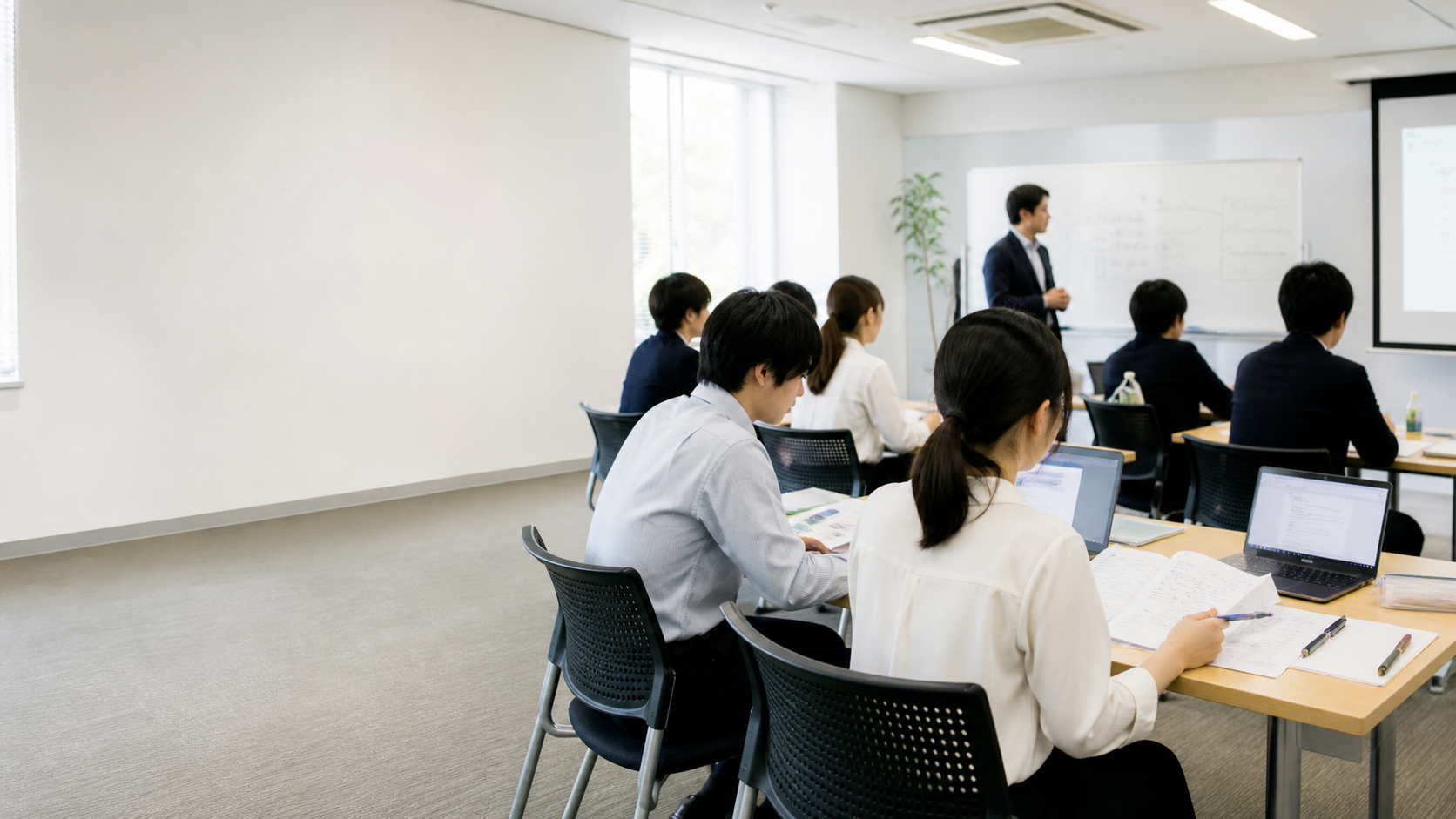 明るい研修室で新人研修を受けている様子