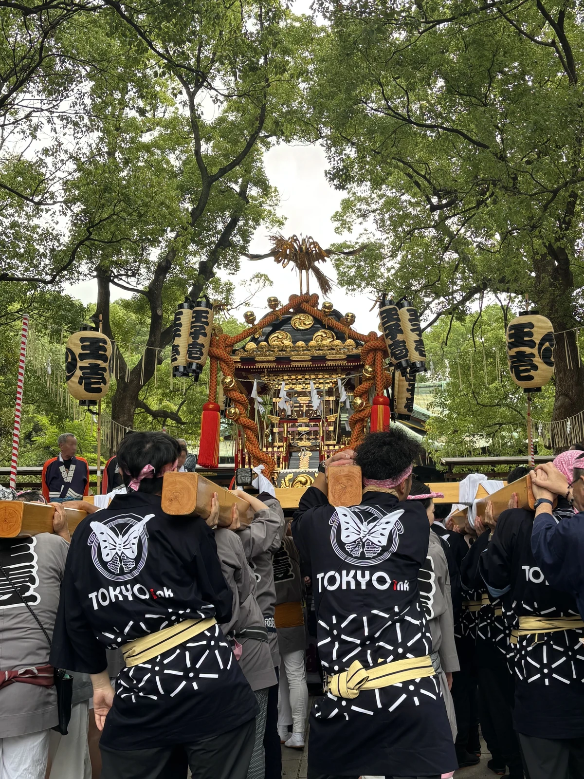 東京インキの社名入りの法被を着て、王子神社例大祭の神輿を担ぐ参加者たち